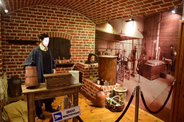 Eine nachgebaute Brennerei mit einer Schaufensterpuppe in historischer Kleidung.