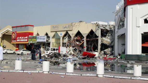 Nach einer Explosion liegen Trümmer vor beschädigten Geschäften.