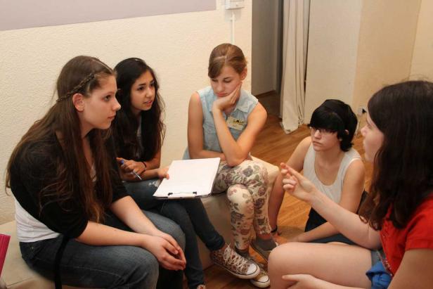 Eine Gruppe junger Frauen sitzt im Kreis und diskutiert.