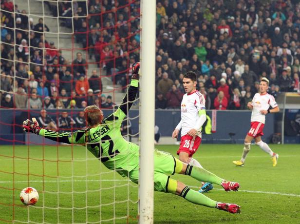 Ein Torwart hechtet nach dem Ball vor einer Zuschauermenge.