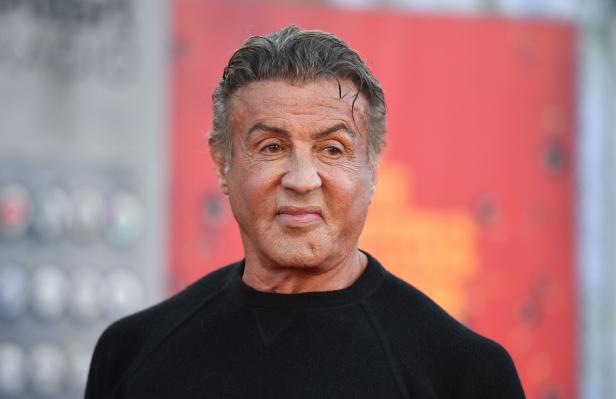 Porträt von Sylvester Stallone vor einem roten Hintergrund.