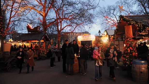 Menschen besuchen den Weihnachtsmarkt Winter Wonderland in London.