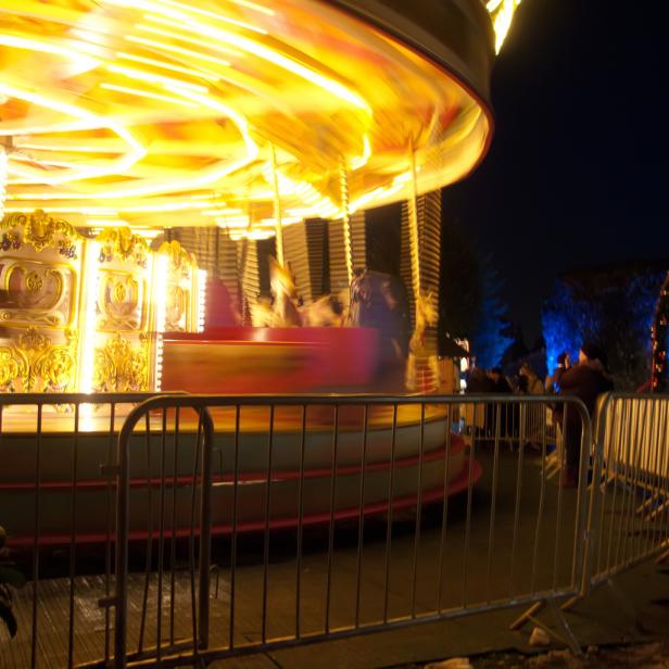 Ein Karussell dreht sich schnell im Dunkeln.