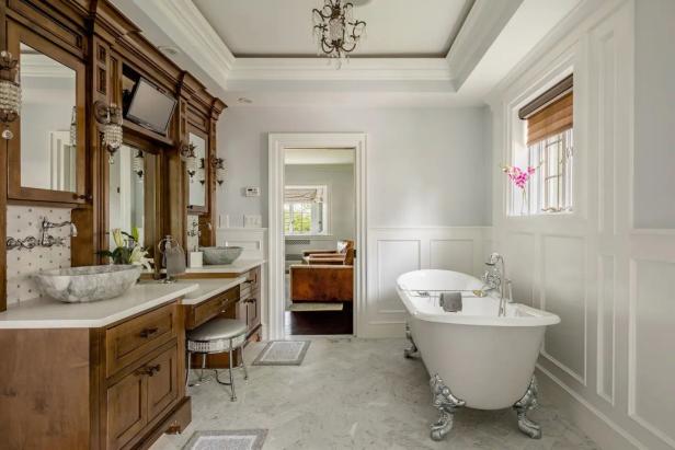 Ein Badezimmer mit freistehender Badewanne und Waschtisch mit Marmorwaschbecken.