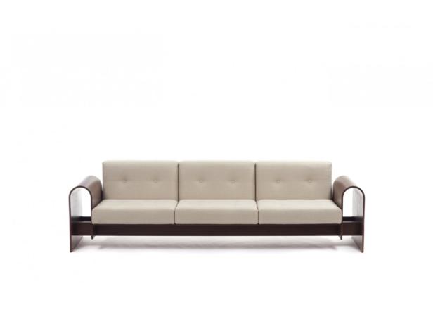 Ein cremefarbenes Sofa mit Holzrahmen steht vor einem weißen Hintergrund.