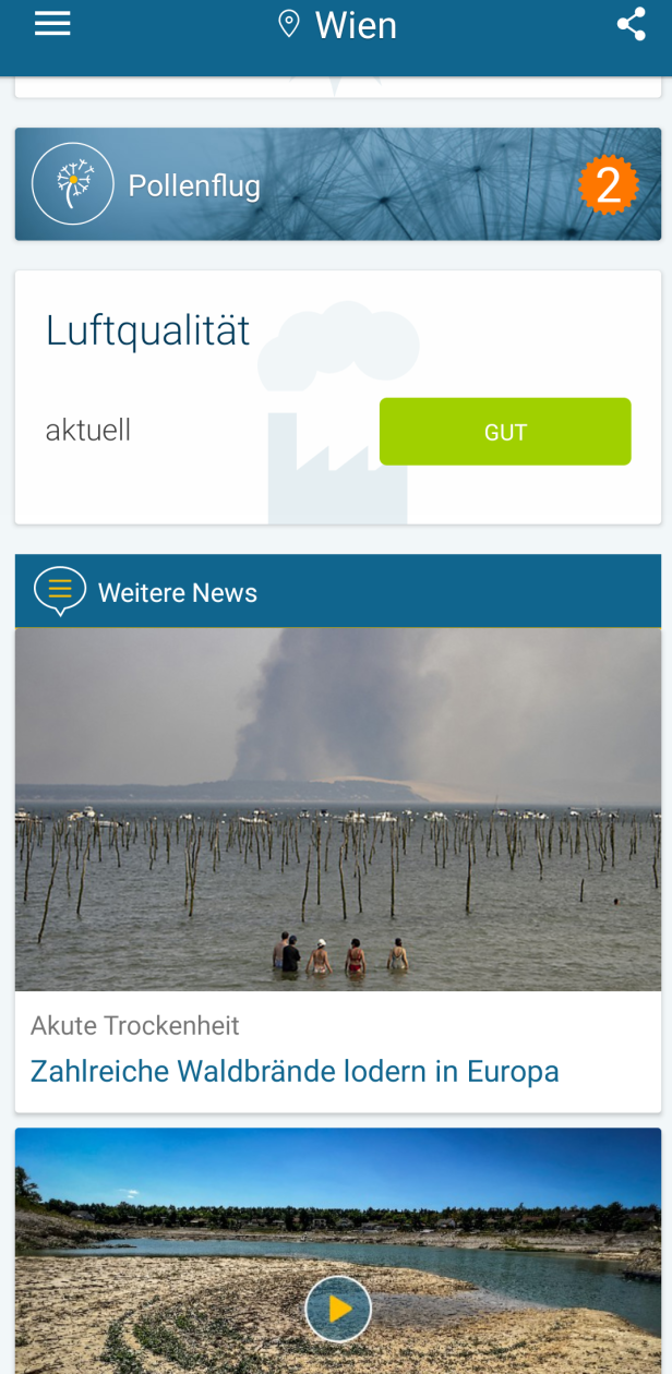 Eine Gruppe von Menschen steht im Wasser; im Hintergrund lodern Waldbrände.