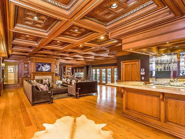 Ein luxuriöses Wohnzimmer mit Holzvertäfelung und einer Bar im Hintergrund.