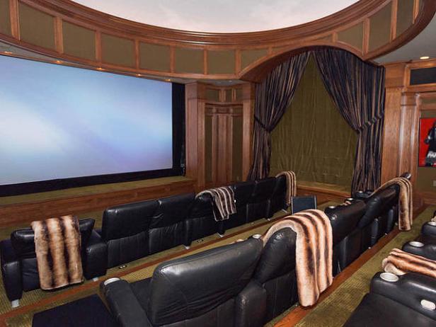 Ein Heimkino mit Ledersitzen und einer großen Leinwand.