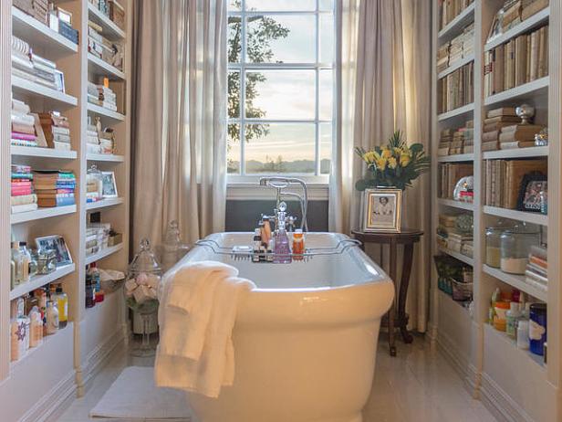 Ein Badezimmer mit einer freistehenden Badewanne, umgeben von Bücherregalen.