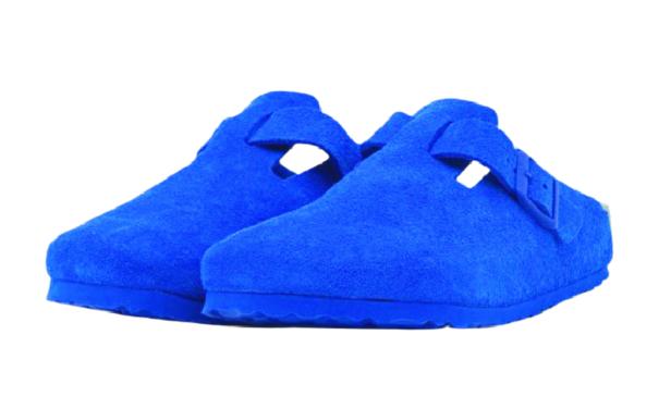 Ein Paar blaue Clogs aus Stoff stehen nebeneinander.