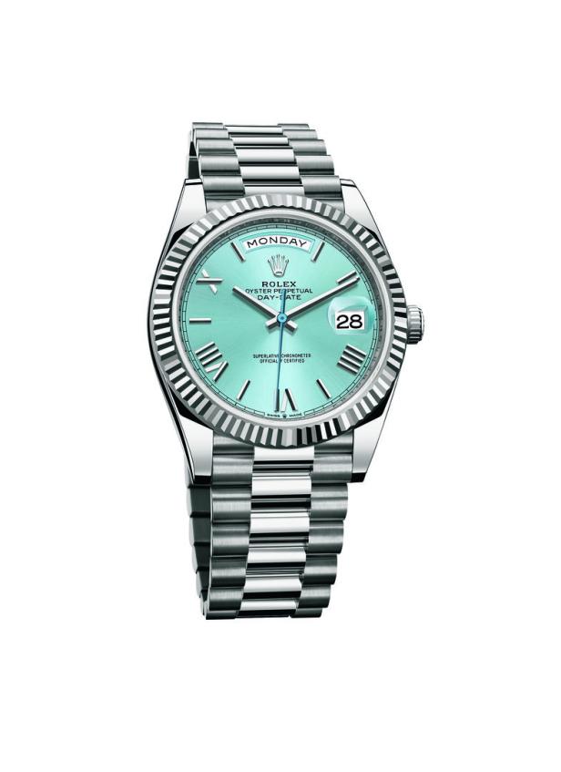 Eine silberne Rolex Day-Date Uhr mit hellblauem Zifferblatt, die „Montag“ und den 28. anzeigt.
