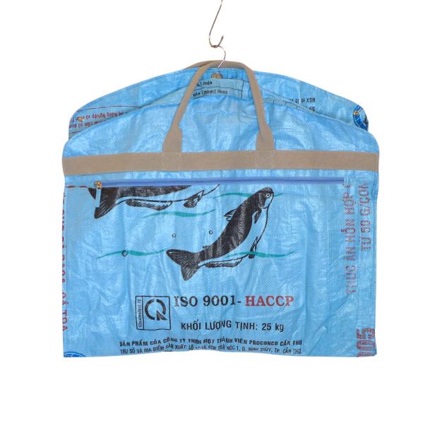 Eine blaue Tasche mit Fischmotiven hängt an einem Kleiderbügel.