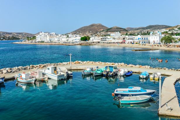 Blick auf den Hafen von Paros mit Fischerbooten und weiß getünchten Häusern.