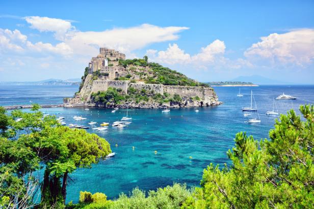 Das Castello Aragonese thront auf einer felsigen Insel vor Ischia, Italien.