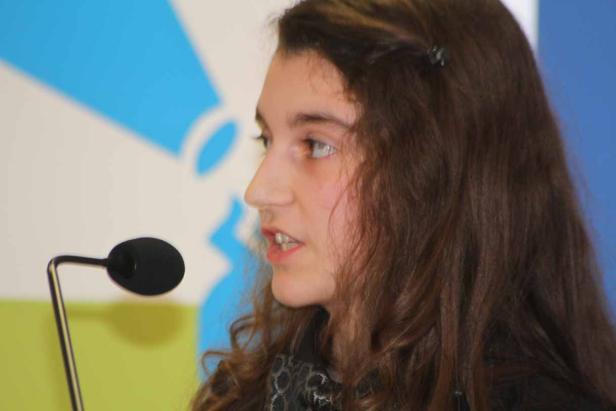 Ein junges Mädchen spricht in ein Mikrofon.