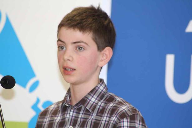 Ein junger Mann spricht vor einem Mikrofon.