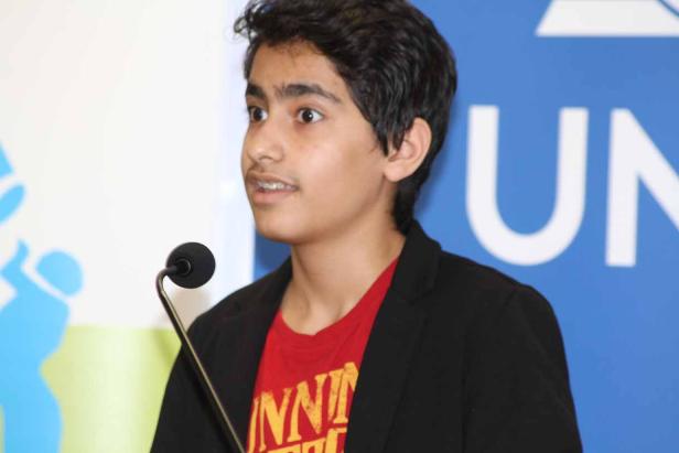 Ein junger Mann spricht am Rednerpult vor einem UN-Hintergrund.