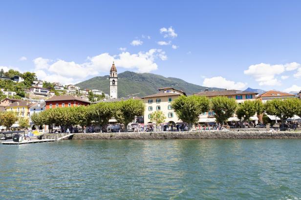 Blick auf den Lago Maggiore mit der Uferpromenade von Brissago und dem Kirchturm.