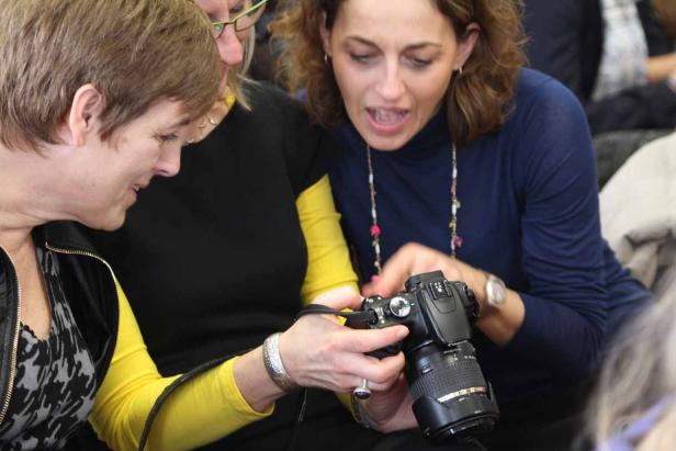 Drei Frauen betrachten gemeinsam die Kamera einer anderen Frau.