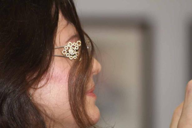 Das Profil einer Frau mit einer verzierten Haarspange im Haar.