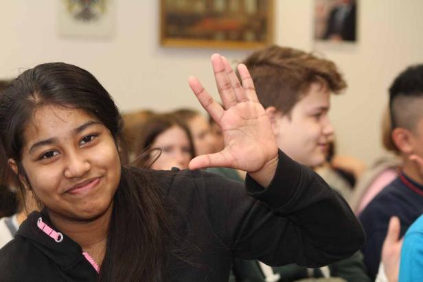 Ein junges Mädchen lächelt und zeigt den vulkanischen Gruß.