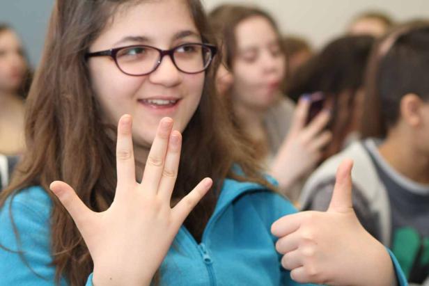 Ein junges Mädchen zeigt den vulkanischen Gruss und einen Daumen nach oben.