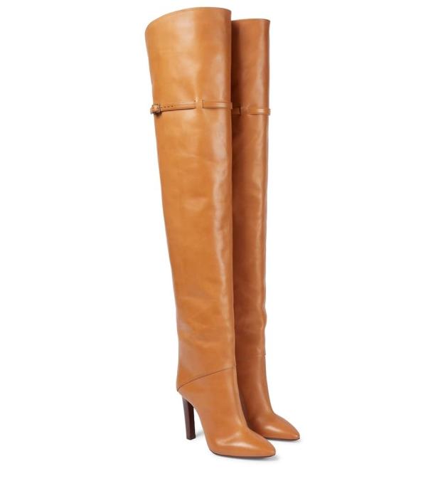Ein Paar hohe, hellbraune Lederstiefel mit Absatz stehen auf einem weißen Hintergrund.