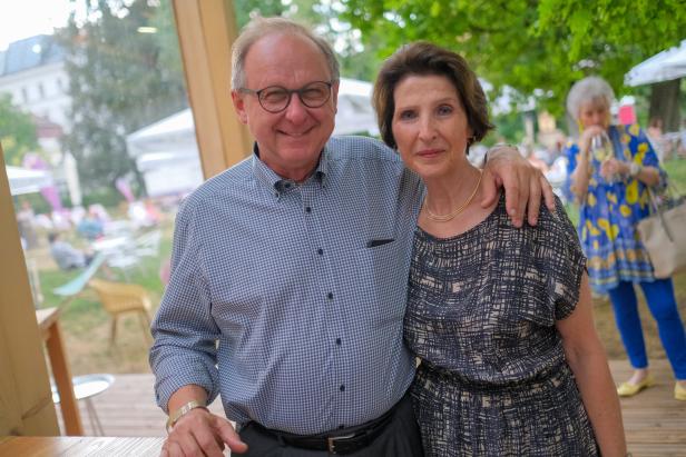 Ein Mann mit Brille umarmt eine Frau im Freien.