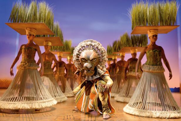 Eine Szene aus dem Musical „Der König der Löwen“ mit Darstellern in Kostümen.