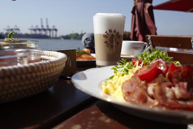 Ein Frühstücksteller mit Rührei, Speck und Tomaten im Restaurant „Strandperle“ in Hamburg.