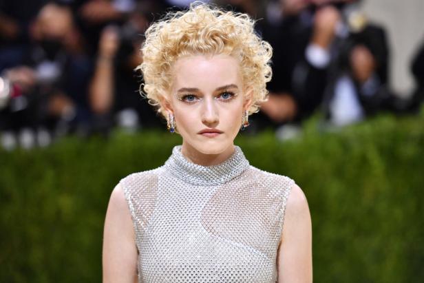 Julia Garner in einem silbernen Kleid mit glitzerndem Make-up.