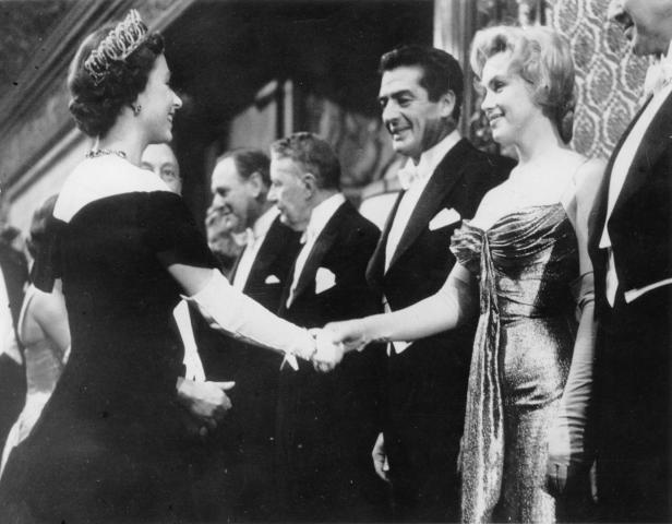 Königin Elisabeth II. schüttelt Hände mit Marilyn Monroe.