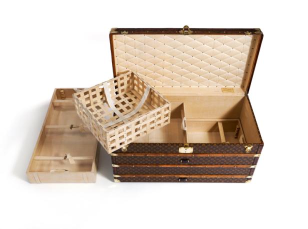 Ein geöffneter Louis Vuitton Koffer mit herausgenommenen Fächern.