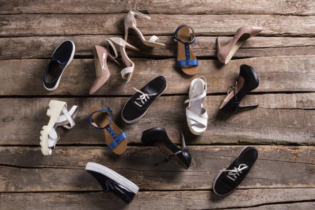 Verschiedene Damenschuhe sind auf einem Holzboden angeordnet.