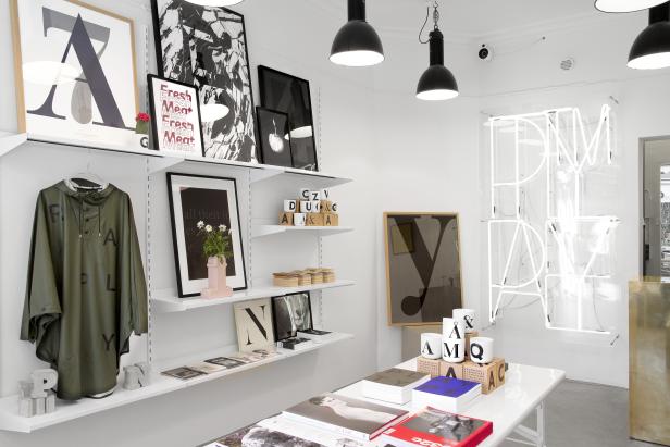 Ein minimalistisch gestalteter Laden mit Regalen voller Bücher, Kunst und Dekorationsgegenstände.