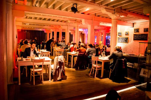 Gäste sitzen an Tischen in einem hell erleuchteten Restaurant.