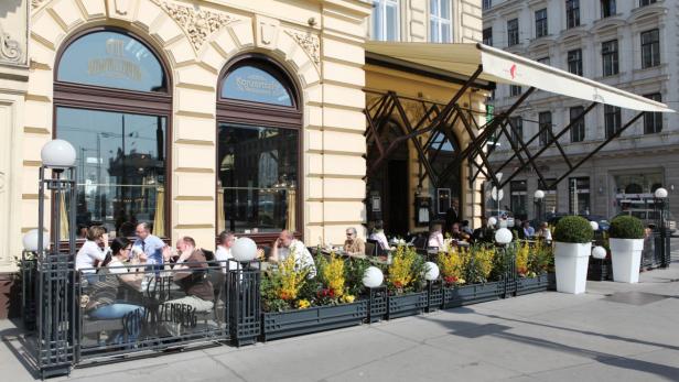 Gäste sitzen im Außenbereich des Café Schwarzenberg in Wien.
