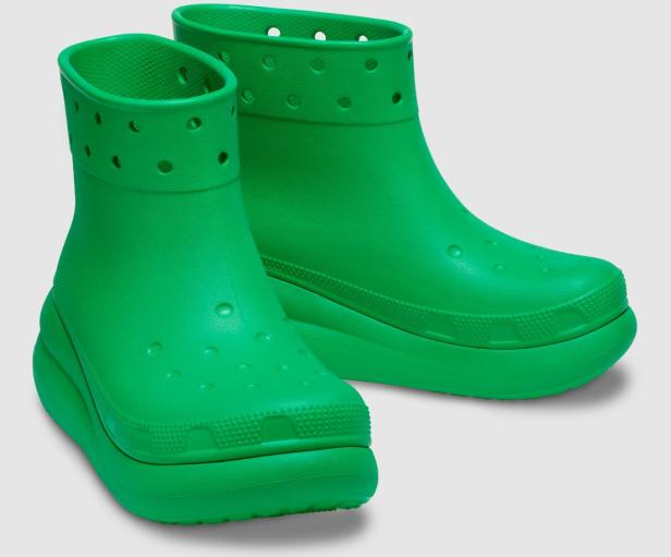 Zwei grüne Crocs-Stiefel mit Plateausohle stehen vor einem neutralen Hintergrund.