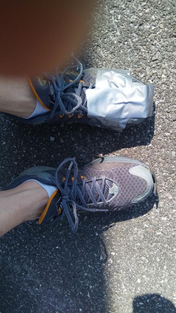 Ein Laufschuh ist mit Panzertape geflickt.