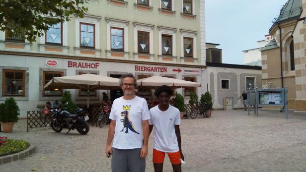 Zwei Männer posieren vor dem „Brauhof Biergarten“.
