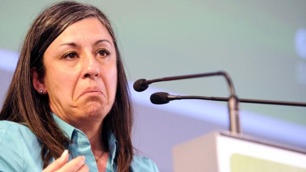 Eine Frau spricht mit besorgter Miene am Rednerpult.