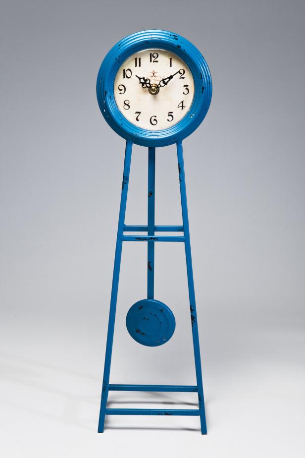 Eine blaue Standuhr mit einem runden Zifferblatt und einem Pendel.