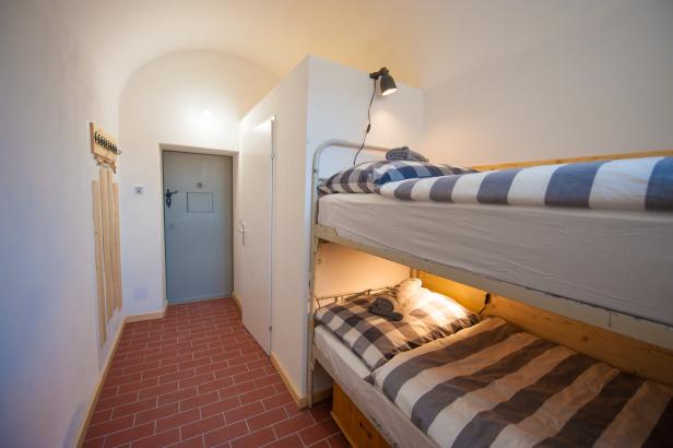 Ein Zimmer mit einem Etagenbett und einem gefliesten Boden.