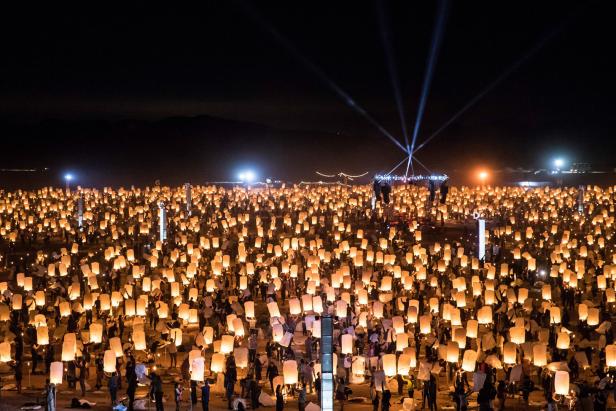 Viele Menschen lassen in der Nacht leuchtende Himmelslaternen steigen.