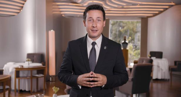 Ein Mann in einem Anzug steht in einem eleganten Restaurant.