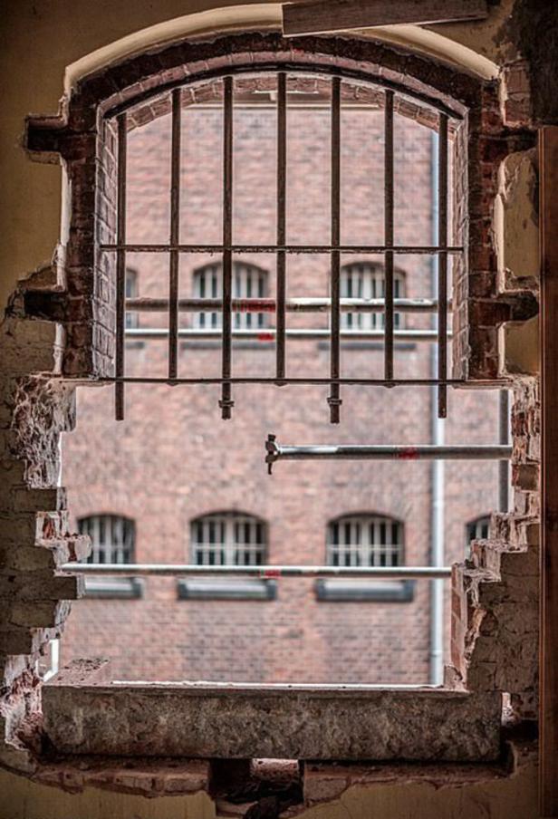 Ein vergittertes Fenster in einem alten, baufälligen Gebäude.