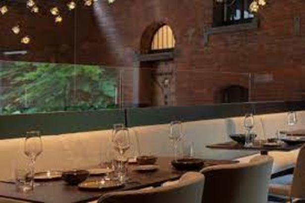 Ein gedeckter Tisch in einem eleganten Restaurant mit Backsteinmauer.