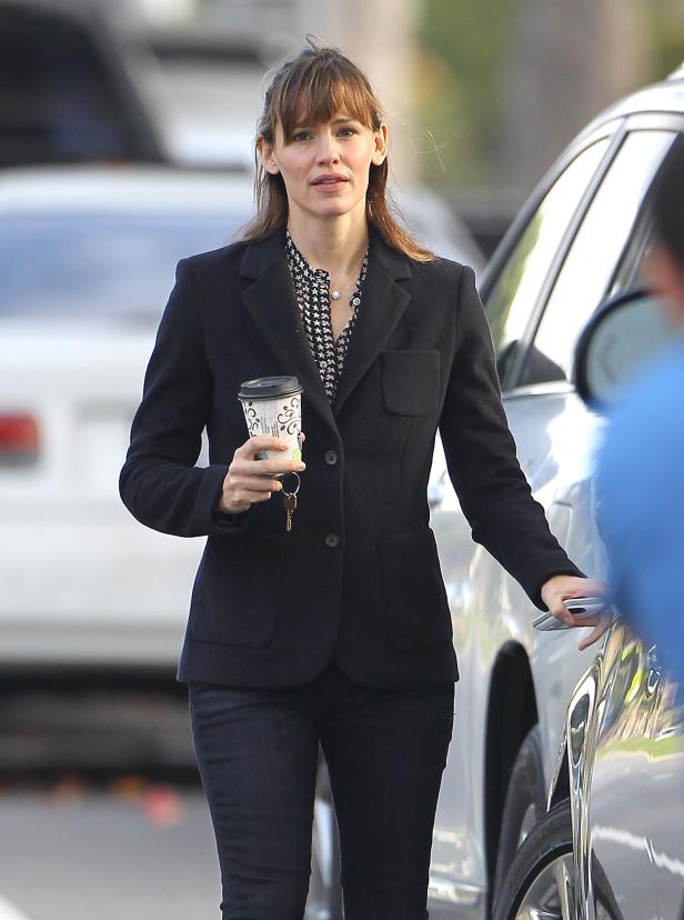 Jennifer Garner mit einem Kaffee in der Hand öffnet eine Autotür.