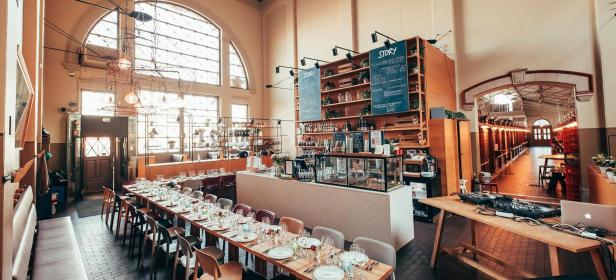Ein Innenraum des Restaurants „Story“ mit gedeckten Tischen und einer Bar.