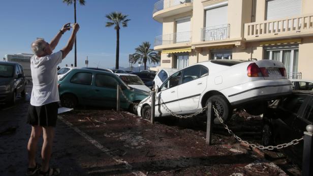 Ein Mann fotografiert in einem Parkhaus die Schäden durch eine Überschwemmung.
